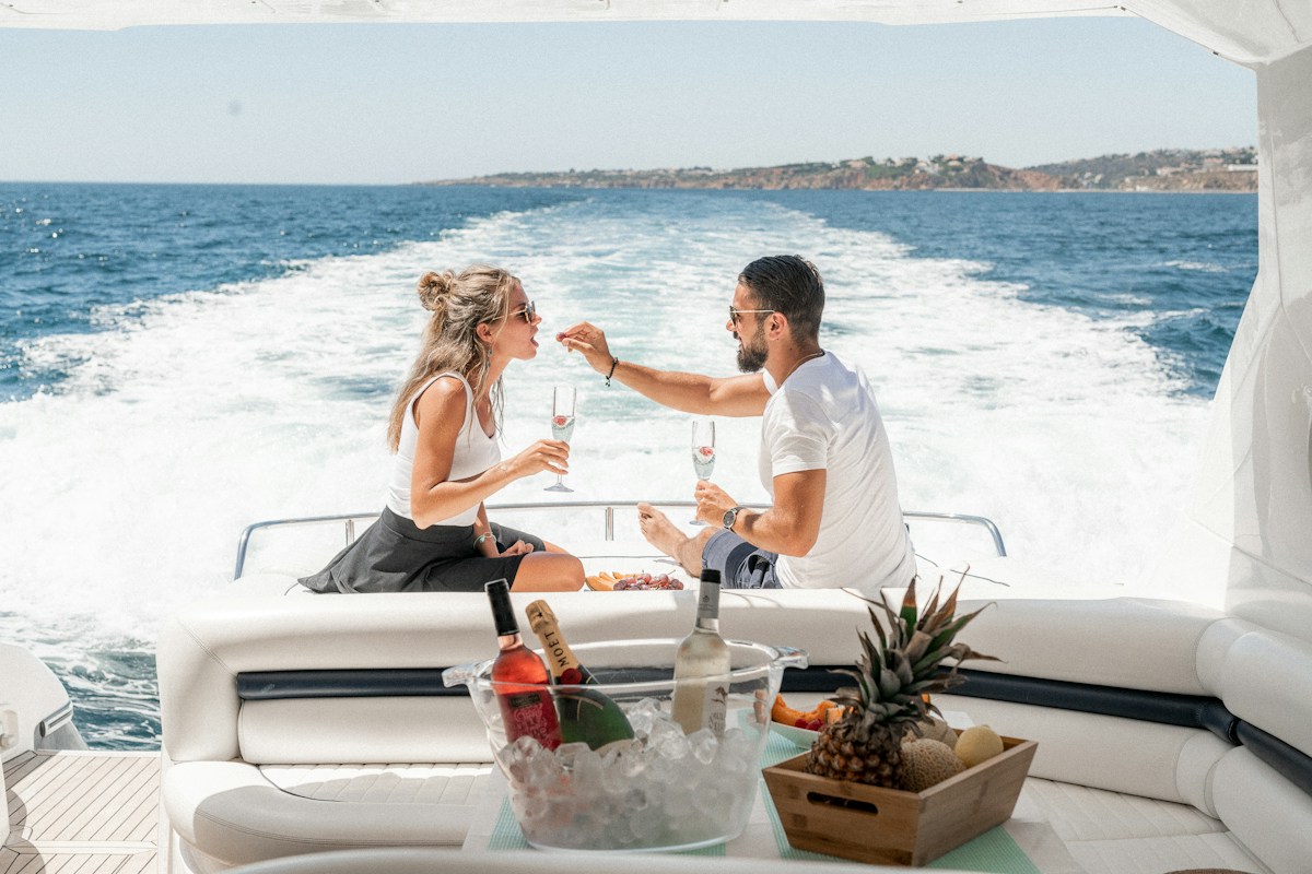Couple enjoying champagne and refreshments aboard a private yacht